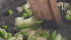 鍋中油7成熱時，入青豆、筍丁翻炒，然后加糯米飯加鹽均勻翻炒。