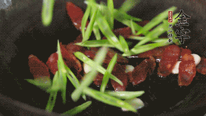 先后下香腸片、四季豆絲均勻翻炒，加適量清水燜煮一下。