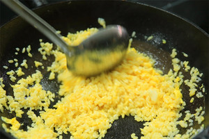 大火加熱炒鍋，再入油，燒到四至五成熱時(shí)倒入雞蛋液，在未凝結(jié)之前，加米飯煸炒，不停翻炒并用鍋鏟將成塊的米飯碾開、撥散。