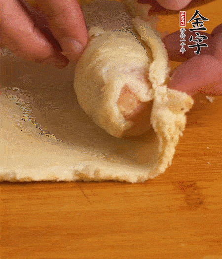 吐司卷起香腸，吐司尾端涂抹少許全蛋液，卷好的吐司表面蘸上蛋液，在裹上一層面包糠，送入預(yù)熱好的烤箱中。