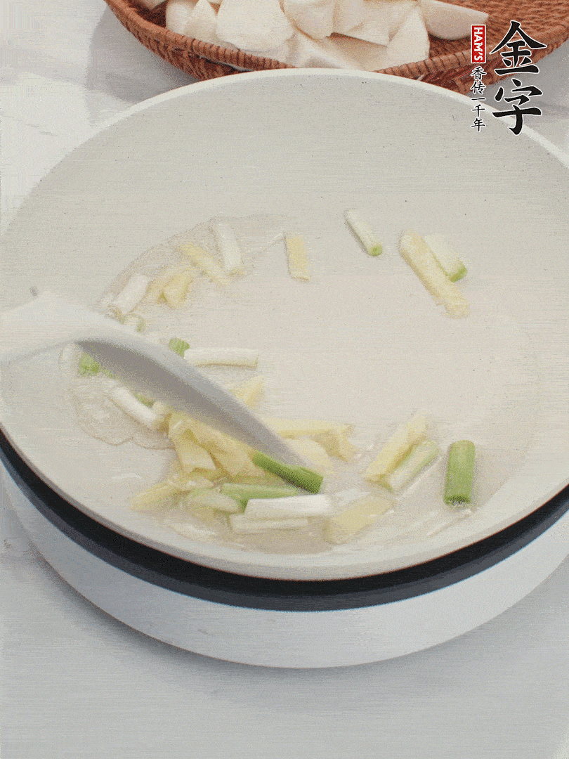 鍋中油五成熱，下蔥白、姜片爆香。