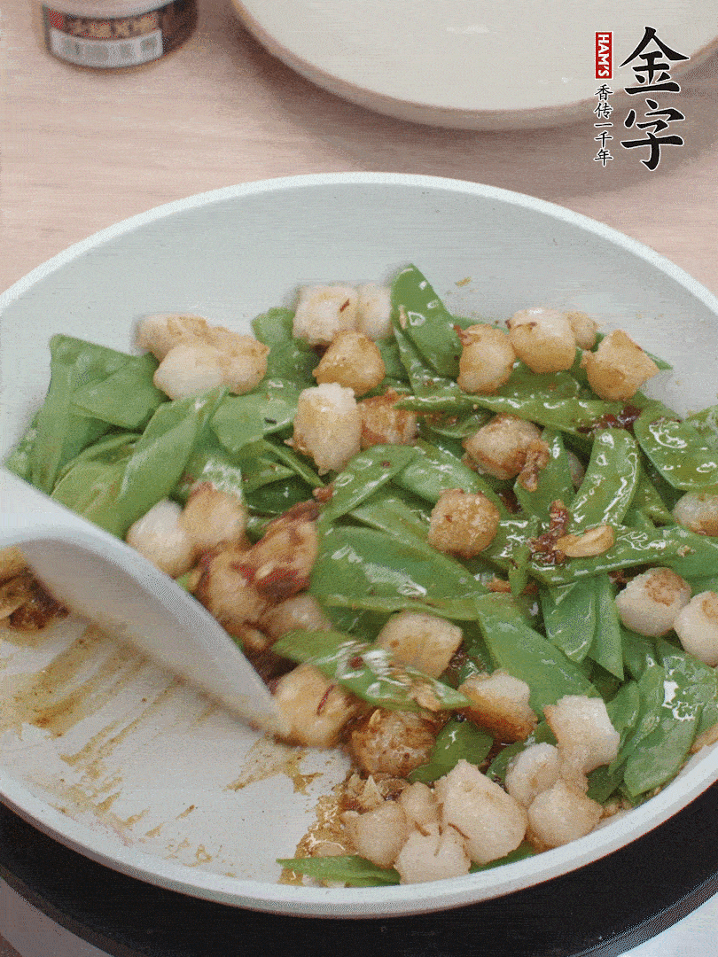 下甜豆莢、鮮貝輕輕翻炒均勻。