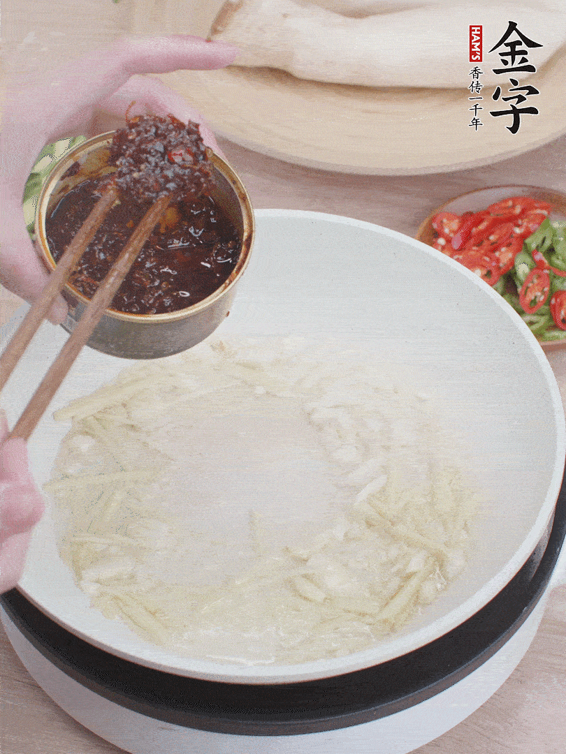 起鍋熱油，姜蒜、金字火腿干貝醬煸香。