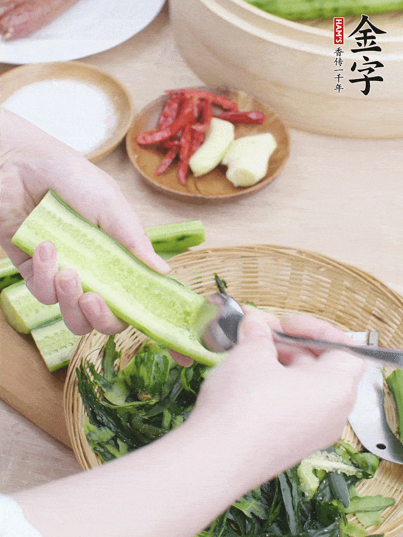 黃瓜削皮，對半切開，勺子挖去內(nèi)瓤，斜刀切片。青蒜斜刀切段。