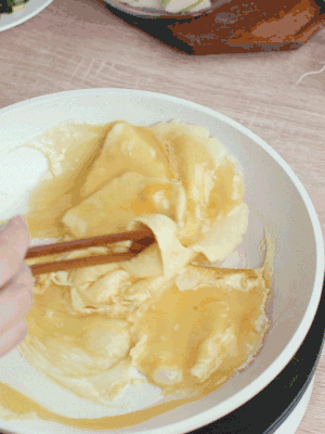 油6成熱時(shí)，下雞蛋液，邊緣凝固時(shí)翻拌成塊狀。