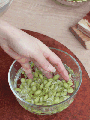 青豆剝殼，搓去外衣。