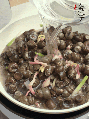倒處理干凈的螺螄翻炒，加3勺料酒。加清水蓋過螺螄，中火蓋蓋煮5分鐘。