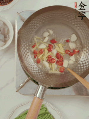 油7成熱時(shí)，下大蒜粒、姜絲、小米辣煸香。