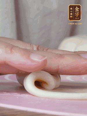 做面劑 油皮按扁，中間包入一個(gè)油酥，邊緣收緊捏死。包好的面劑按扁，用搟面杖搟壓成橢圓形。從底部向上卷成筒狀，用保鮮膜蓋好松弛15分鐘，再把筒狀縱向搟壓成長(zhǎng)條狀。再卷一次，松弛20分鐘