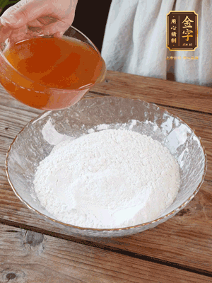 轉(zhuǎn)化糖漿、枧水、花生油攪拌均勻，加入面粉混合，醒發(fā)2小時。捏成23g一個的小球