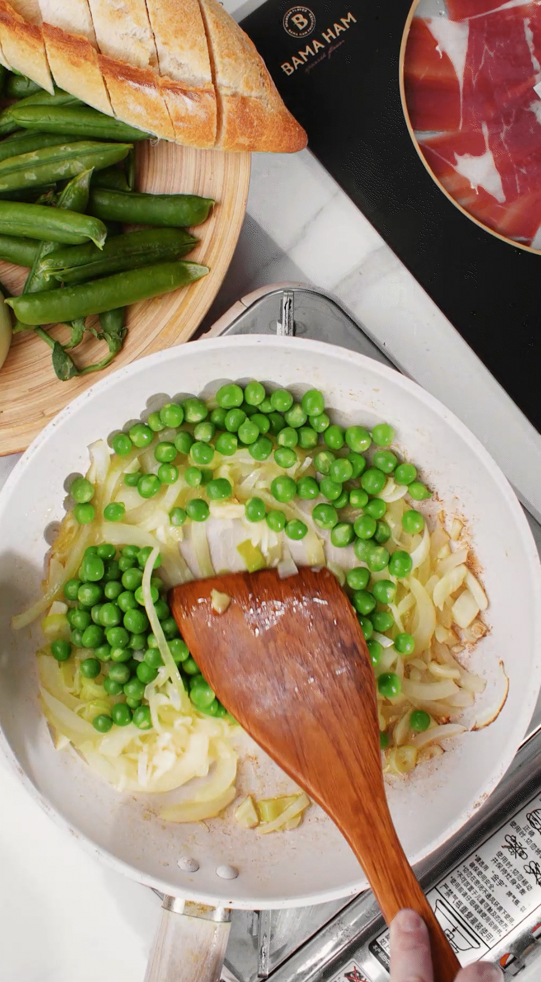 鍋中放入黃油融化，加入洋蔥絲、大蔥蔥白絲、蒜末翻炒變軟出香味。加入剛剛汆燙冰鎮(zhèn)后的豌豆，取出一點點待會擺盤裝飾用。加一點鹽 (和黑胡椒) 調(diào)味。
