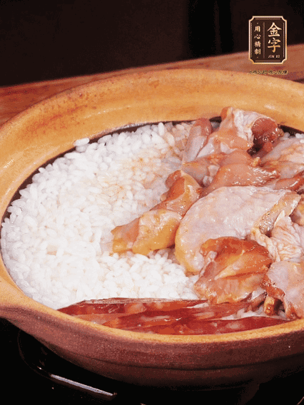 煮到椰子水微微收干轉(zhuǎn)小火，快速均勻鋪上雞肉、金字香腸