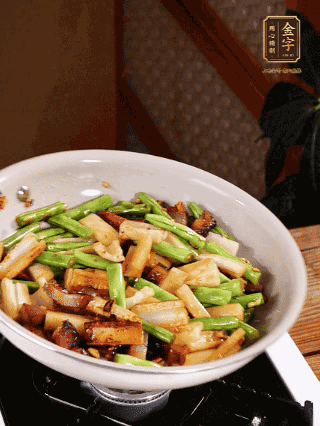 油熱下蒜末、干辣椒、醬肉煸炒出香味，依次下藕條、豆角翻炒均勻